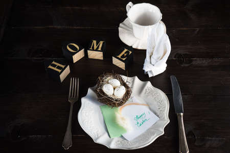 Festive table setting for holiday Easter dinner on dark wooden table with copyspaceの写真素材