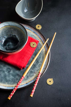 Rustic table setting with chopsticks for dinner in asian style  on dark wooden table with copyspaceの写真素材
