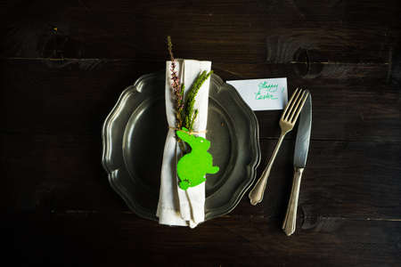 Festive table setting for holiday Easter dinner on dark wooden table with copyspace