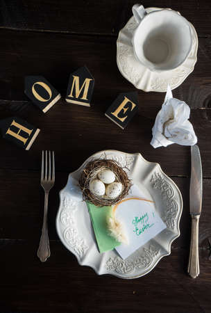 Festive table setting for holiday Easter dinner on dark wooden table with copyspace