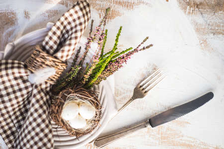 Festive table setting for holiday Easter dinner on dark wooden table with copyspace