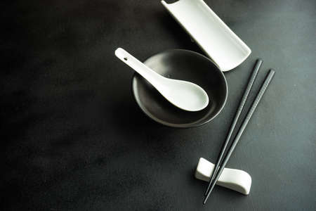 Rustic table setting with chopsticks for dinner in asian style  on dark wooden table with copyspaceの写真素材