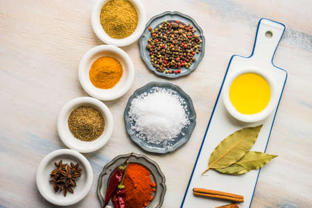 Spices and herbs in ceramic bowls on rustic wooden background with copyspaceの写真素材