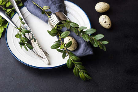 Festive table setting for holiday Easter dinner on dark wooden table with copyspace