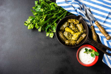 Traditional georgian dolma in grape leaves on rustic wooden table with copyspace