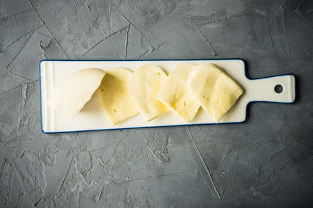 Traditional georgian cheese suluguni on ceramic cutting boardの写真素材