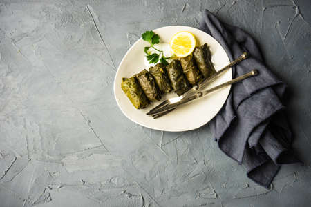 Traditional georgian dolma in grape leaves on rustic wooden table with copyspaceの写真素材