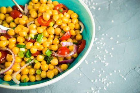 Homemade spicy vegetarian stew with chickpeas and vegetables on rustic wooden background with copy space. Organic food conceptの写真素材