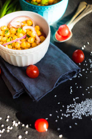 Homemade spicy vegetarian stew with chickpeas and vegetables on rustic wooden background with copy...