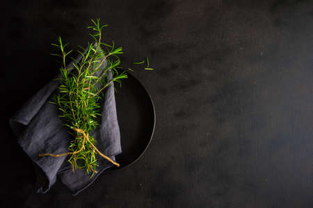 Fresh rosemary spice on rustic background as a cooking conceptの写真素材