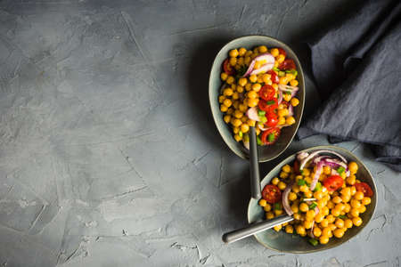 Homemade spicy vegetarian stew with chickpeas and vegetables on rustic wooden background with copy space. Organic food conceptの写真素材