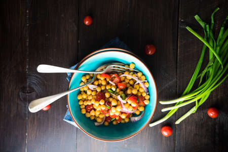 Homemade spicy vegetarian stew with chickpeas and vegetables on rustic wooden background with copy space. Organic food conceptの写真素材