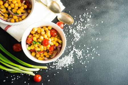 Homemade spicy vegetarian stew with chickpeas and vegetables on rustic wooden background with copy space. Organic food conceptの写真素材