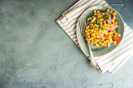 Homemade spicy vegetarian stew with chickpeas and vegetables on rustic wooden background with copy space. Organic food conceptの写真素材