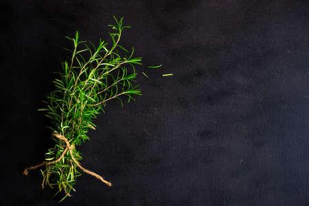 Fresh rosemary spice on rustic background as a cooking conceptの写真素材