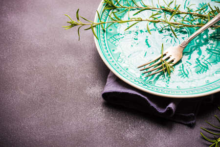 Summer time table setting with fresh rosemary spice on rustic background with copy spaceの写真素材