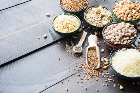 Organic superfood concept with raw chick peas, buckwheat, beans, rice, chia and flax seeds on wooden backgroundの写真素材