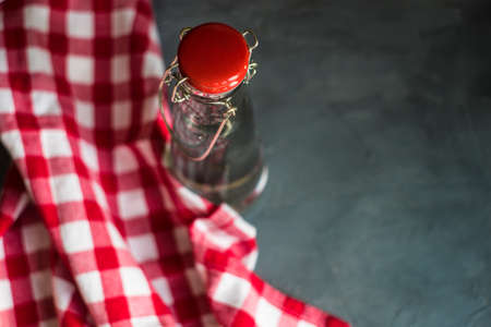 Vintage bottle of fresh water and red towel on concrete tableの写真素材