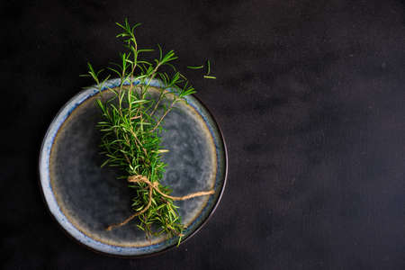 Fresh rosemary spice on rustic background as a cooking concept