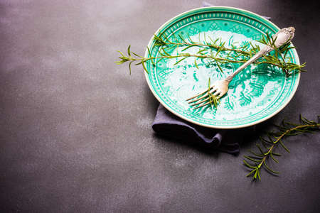 Summer time table setting with fresh rosemary spice on rustic background with copy spaceの写真素材