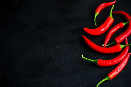 Red chilli peppers on dark wooden background with copy spaceの写真素材