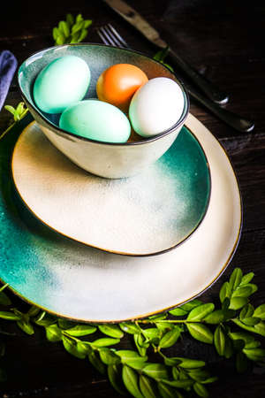 Table setting for holiday Easter dinner on dark wooden table with copy spaceの写真素材