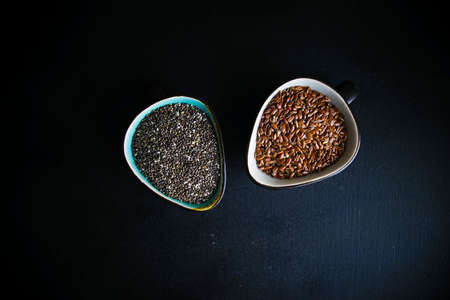 Superfood - chia and flax seeds in a ceramic bowl on black table with copy spaceの写真素材