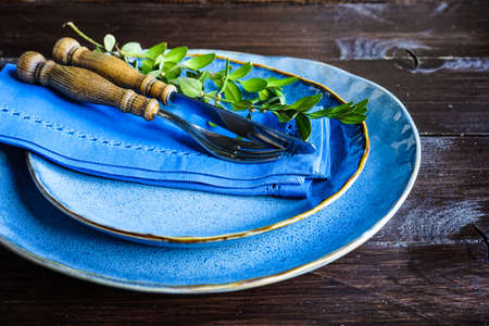Table setting for holiday Easter dinner on dark wooden table with copy spaceの写真素材