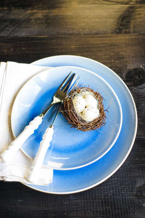 Table setting for holiday Easter dinner on dark wooden table with copy space