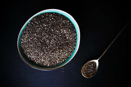 Superfood - chia and flax seeds in a ceramic bowl on black table with copy spaceの写真素材
