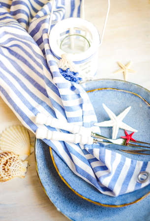 Summertime table setting in marine style on white rustic tableの写真素材