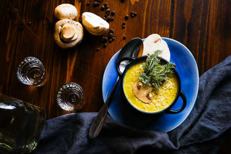 Rustic dinner set with healthy   mushroom cream soup with spices on dark wooden tableの写真素材