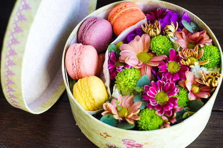 Gift box full of summer flowers and french sweets - macaroonsの写真素材