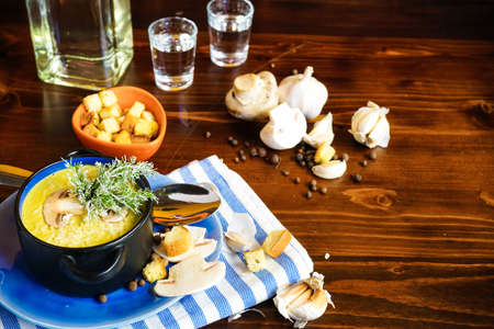 Rustic dinner set with healthy   mushroom cream soup with spices on dark wooden tableの写真素材