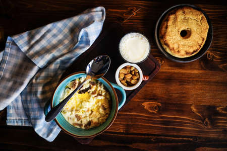 Rustic georgian breakfast set with healthy corn and milk porridge  on dark wooden table