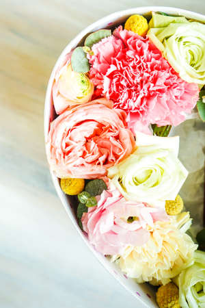 Heart shaped gift box full of anemone flowers on dark background with copy spaceの写真素材