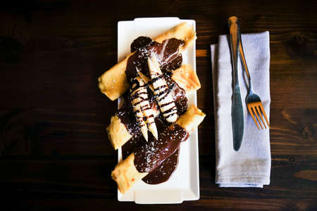Traditional dessert banana pancakes with chocolate and nutsの写真素材