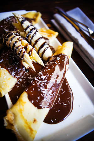 Traditional dessert banana pancakes with chocolate and nutsの写真素材