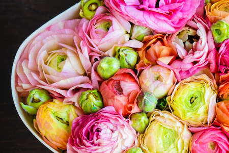 Heart shaped gift box full of anemone flowers on dark background with copy spaceの写真素材