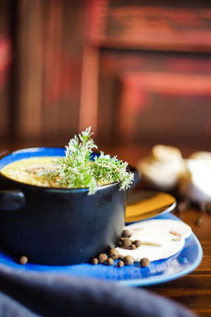 Rustic dinner set with healthy   mushroom cream soup with spices on dark wooden tableの写真素材