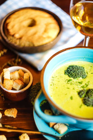 Rustic dinner set with healthy broccoli cream soup on dark wooden tableの写真素材