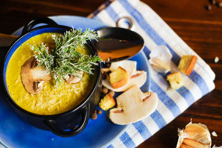 Rustic dinner set with healthy   mushroom cream soup with spices on dark wooden tableの写真素材