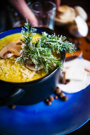 Rustic dinner set with healthy   mushroom cream soup with spices on dark wooden tableの写真素材