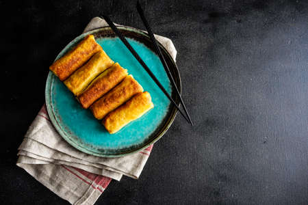 Stuffed pancakes crepes with meat and cream sauce on dark wooden table with copyspaceの写真素材