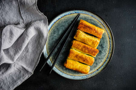 Stuffed pancakes crepes with meat and cream sauce on dark wooden table with copyspace