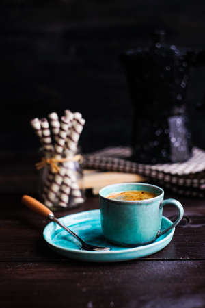 Cup of coffee, coffee pot and sweets on rustic table with copyspaceの写真素材