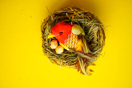 Easter holiday card with nest on bright yellow background with copy space