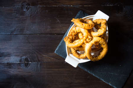 Fried onion rings and sauce on wooden table with copyspaceの写真素材