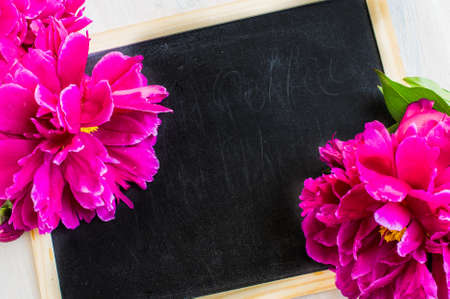 Bright purple peony flowers on rustic wooden table with copyspaceの写真素材