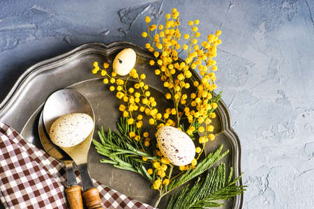 Spring table setting with bright yellow mimosa flowers